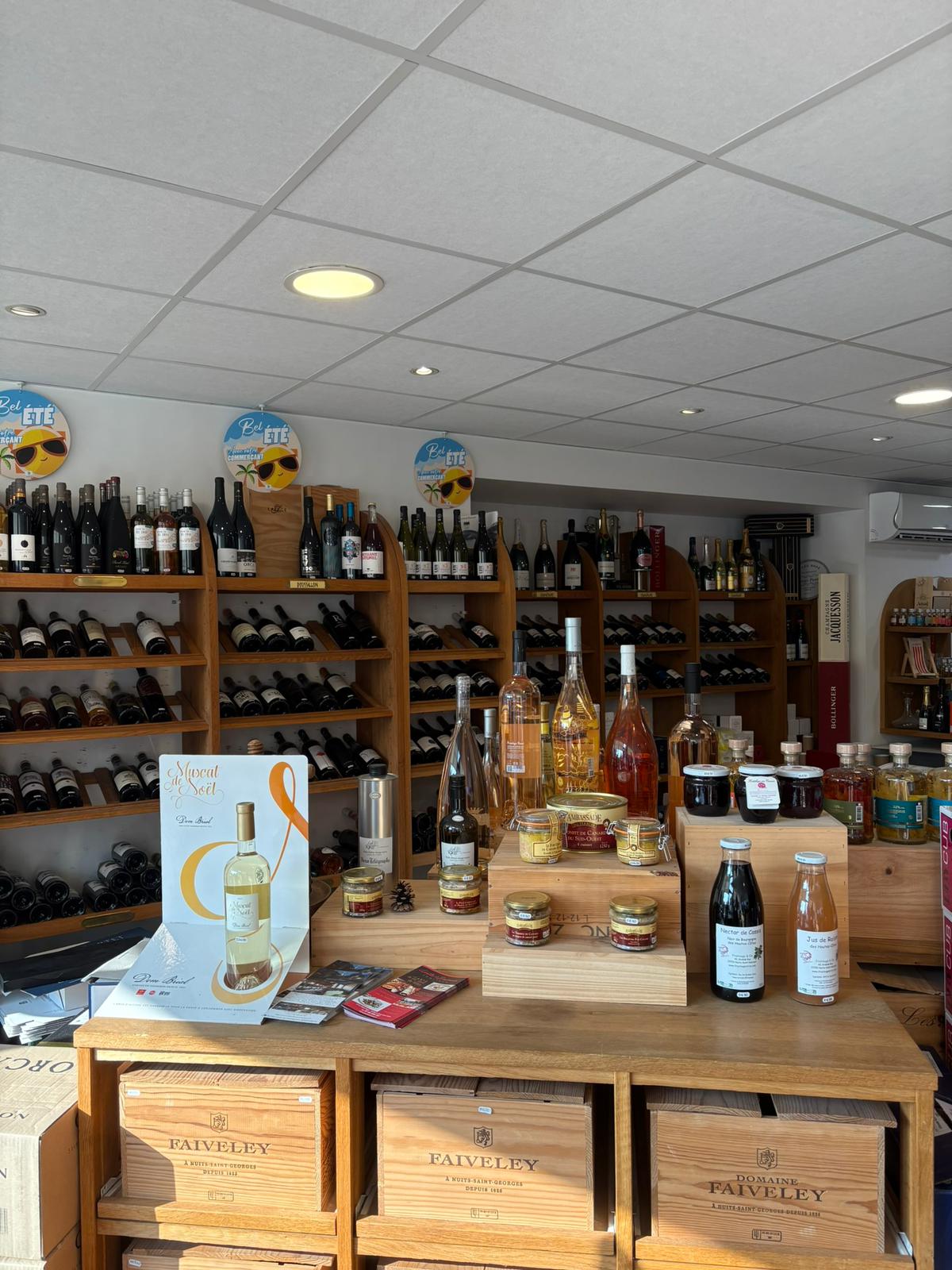 Coffrets, bouteilles et épicerie fine sur une table en bois à La Cave Solognote